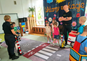 Dziewczynki przechodzą po pasach na drugą stronę ulicy.