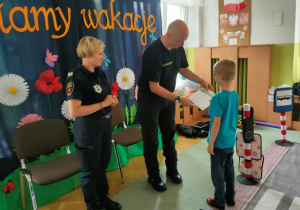 Chłopiec w imieniu wszystkich przedszkolaków wręcza Przedstawicielom Straży Miejskiej w Łodzi okolicznościowy dyplom.