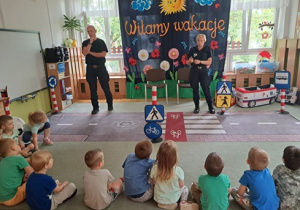 Funkcjonariusze opowiadają dzieciom co będzie na zajęciach.