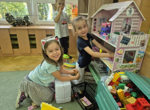 Dziewczynki bawią się na dywanie.