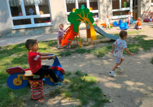 Dzieci bawią się na sprzęcie ogrodowym.