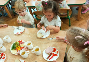 Dzieci jedzą przygotowane przez siebie kanapki.