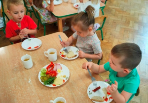 Dzieci jedzą w ciszy śniadanie.