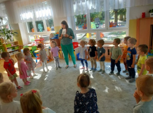 Dzieci stoją w dużym kole, słuchają rymowanki o żabce.