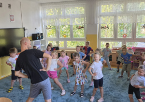 Dzieci biorą udział w zajęciach taneczno-rytmicznych z Panem Darkiem.