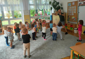 Przy dźwiękach muzyki dzieci odtwarzają elementy gumisiowego tańca.