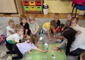 Dziewczynka podaje polecenia robotowi poprzez umieszczenie na jego drodze specjalnej karty.