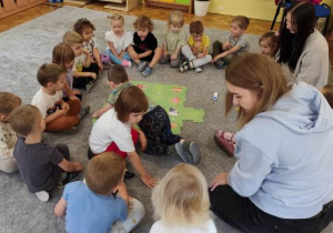 Dzieci rozkładają matę do kodowania na dywanie.