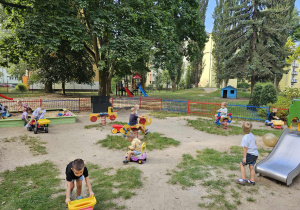 Dzieci bawią się w mniejszym ogrodzie.