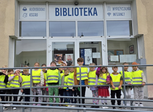Dzieci stoją przed wejście do Biblioteki Miejskiej na Pięknej.