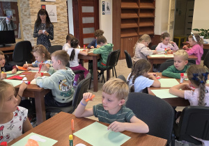Dzieci wykonują pracę plastyczną - muchomorki.