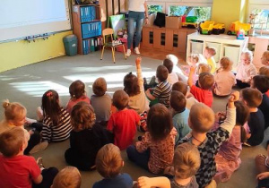Dzieci z uwagą słuchają wypowiedzi gościa.