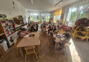 Wspólne zdjęcie dzieci przy stolikach.