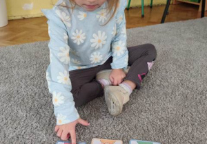 Dziewczynka poprzez wskazanie obrazka pokazuje co czuje gdy ktoś zabierze jej zabawkę.