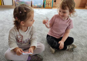 Dziewczynka za pomocą mimiki twarzy przedstawia emocje zilustrowaną na obrazku.