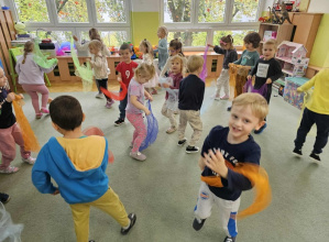 Dzieci tańczą do muzyki klasycznej z chustami.