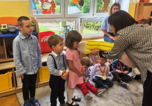 Pani Dyrektor pasuje dziewczynkę z grupy Motylki na przedszkolaka.