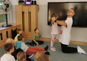 Pan Kamil prezentuje kroki taneczne wspólnie z jedną z dziewczynek.