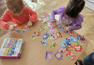 Dziewczynki układają puzzle o emocjach.