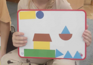 Dziewczynka i obrazek z figur geometrycznych.