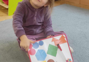 Dziewczynka i kompozycja z figur geometrycznych.