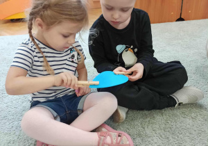 Dzieci podają sobie kropelkę wody przy użyciu spinaczy.