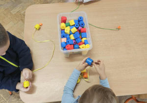 "Korale dla mamy" - zabawa w nawlekanie.