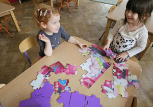 Dziewczynki układają puzzle.