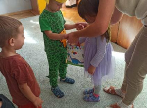 Chłopiec częstuje cukierkami kolegów.