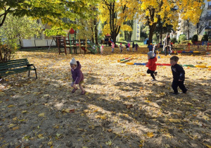 Dzieci biegają po ogrodzie.