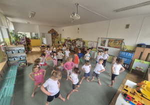 Dzieci rozgrzewają bioderka.