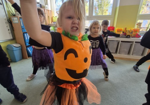 dziewczynka stoi na dywanie i robi straszną minę.