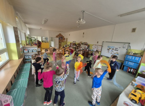 Zabawy ruchowe na dywanie z kolorowymi chustami.