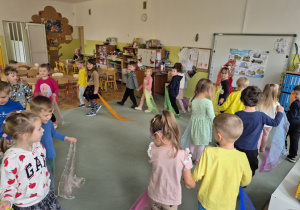 Dzieci tańczą w parach na dywanie.