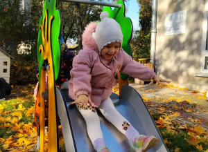 Dziewczynka korzysta ze zjeżdżalni.