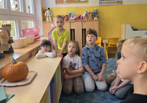 Dzieci obserwują reakcję chemiczną powstałą w środku dyni i rozmawiają na jej temat z Panią Kasią.