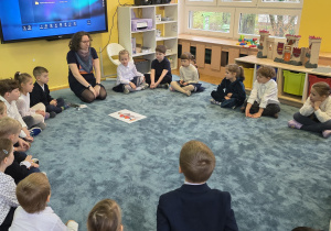 Pani prowadząca wita się z dziećmi i opowiada o temacie dzisiejszego spotkania.