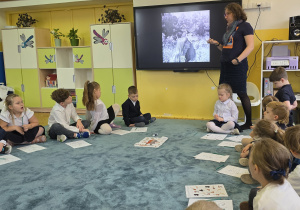 Dzieci oglądają zdjęcia dotyczące różnych bohaterów, m.in. Simony Kossak.