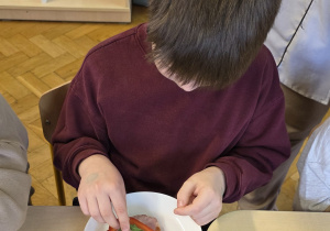 Chłopiec przygotowuje zdrową kanapkę podczas śniadania.