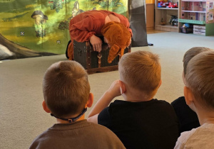 Aktor w przebraniu Gagatka próbuje otworzyć znaleziony skarb.