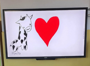 Żyrafa i czerwone serce na tablicy interaktywnej.