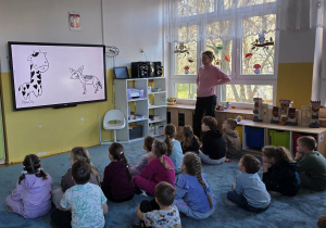 Dzieci oglądają film edukacyjny dotyczący porozumiewania się między sobą.