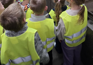 Dzieci obserwują maszynę, dzięki której bombki są posrebrzane.