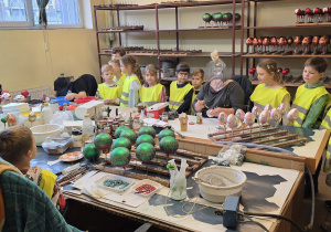 Dzieci obserwują pracę pań odpowiedzialnych za dekorowanie ozdób choinkowy.