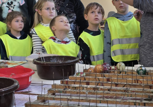 Dzieci słuchają jak w prosty sposób ozdobić bombkę.