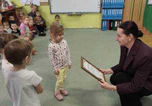Dzieci wręczają podziękowanie za wsparcie akcji "Cała Polska czyta dzieciom".