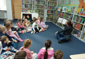Dzieci słuchają książeczki pt. „Fajny Cieciorek i prezent wszechczasów”.