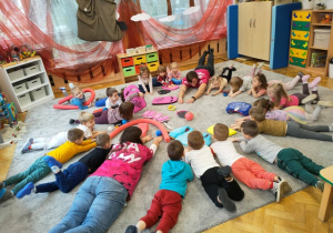 Dzieci leżą na brzuchu- naśladują ruch stylu żabką.