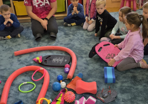 Dziewczynka zastanawia się do czego służy deska, którą trzyma w dłoniach.