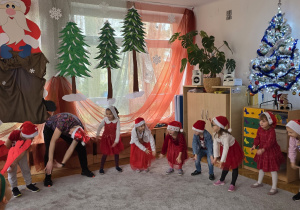 Biedronki i Ważki stoją w kole i powtarzają ruchy taneczne po Panu Darku.